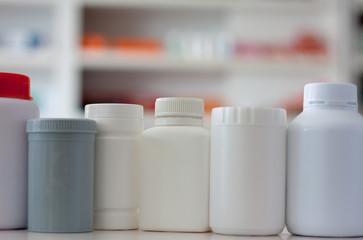 many medicine bottle with blur shelves of drug in the pharmacy d