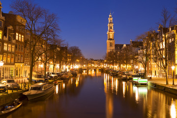 Fototapeta na wymiar The Western Church and a canal in Amsterdam at night