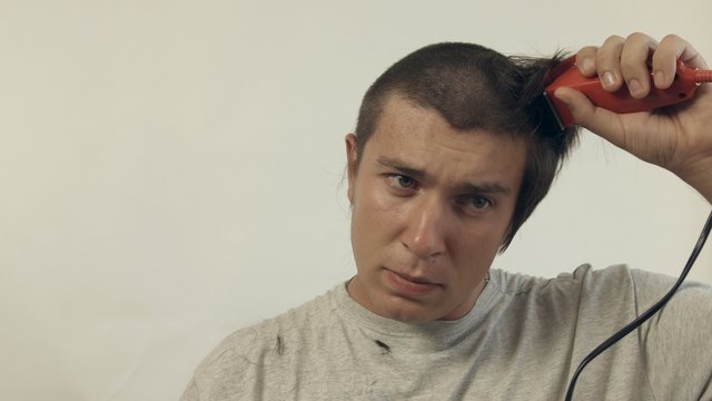 Changing the style, the guy shaves hair on the head with the