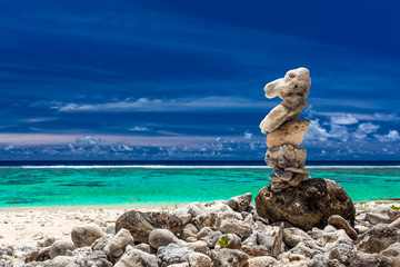 Stack of reef stones against sky and beach of Cook Islands
