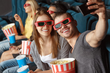 Two friends making selfie in the cinema