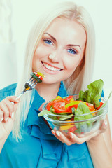 Beautiful girl eating fresh vegetable salad