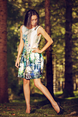 Naklejka premium Beautiful young fashion woman in color dress posing outdoor in g
