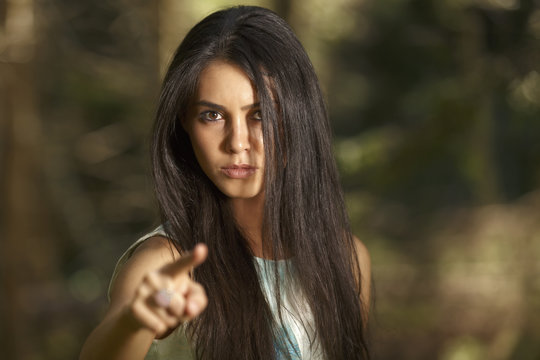 Closeup portrait of young angry woman pointing at someone as if