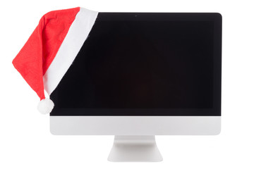 Rote Weihnachtsmütze auf dem modernen Computerbildschirm