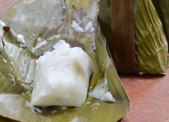steamed flour with coconut filling on banana leaf