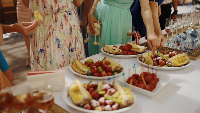 People eat fruits on the party outdoor.