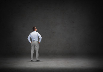 businessman looking at concrete wall background
