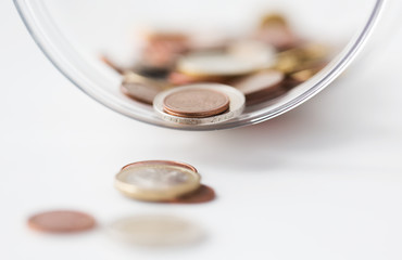 close up of euro coins in glass jar on table