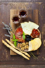 Snacks on a clay plate with wine Marsala . on wooden background.