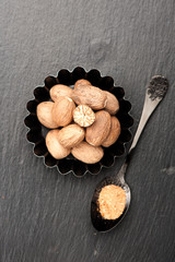 Nutmeg spice on a black background. Top view, vertical