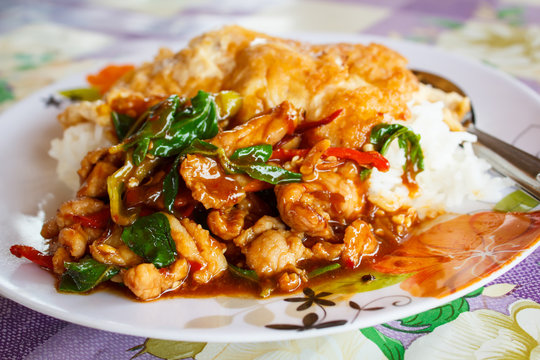 Rice topped with stir fried hot and spicy pork with basil and om