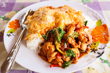 Rice topped with stir fried hot and spicy pork with basil and om