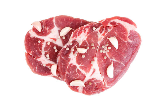 raw steaks of pork neck seasoned with pepper and garlic