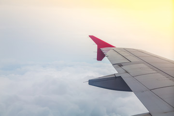 Obraz premium Wing of an airplane flying above the clouds