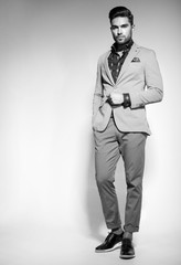 attractive fashion male model dressed elegant - casual posing against wall