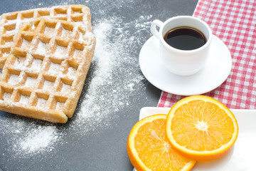 Waffles,oranges and coffee on the kitchen table