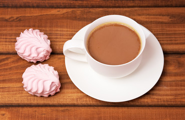 Cup of coffee and cakes on wooden background.