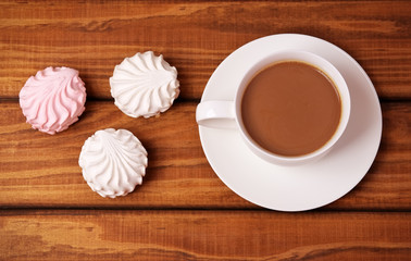 Cup of coffee and cakes on wooden background.