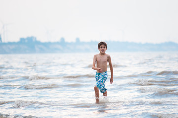 boy playing in the water at the shore of lake Erie