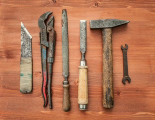 old rusty construction instruments on the wooden background