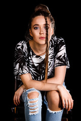 Portrait of a young woman over black background