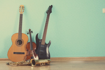 Fototapeta premium Musical instruments on turquoise wallpaper background