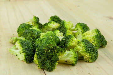 Fresh green broccoli on wooden cutting board close up