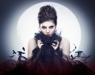 Lovely young female vampire in the night moon.
