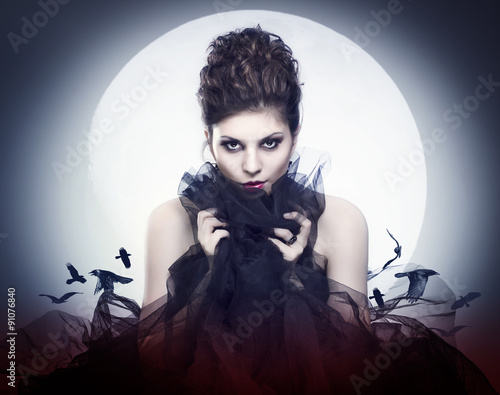 Lovely young female vampire in the night moon.