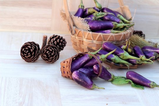 Purple eggplants fresh for cooking on wood background.