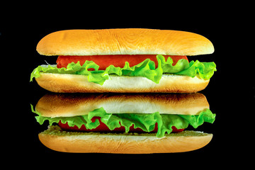 hot dog with fresh leaf lettuce with reflection isolated on a black background