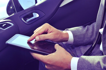 businessman using a tablet in a car