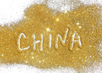 Inscription China on golden glitter sparkles on white background
