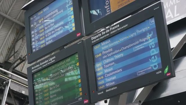 Low angle medium shot of schedule on visual screens in train station / Paris, France