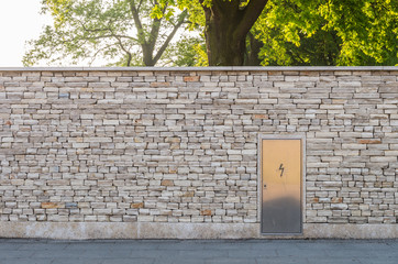 Stone wall made of small limestone bricks with transformer door