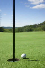 Obraz premium Golf ball at the edge of the hole.