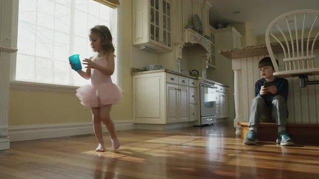 Medium slow motion panning shot of children playing in kitchen / Cedar Hills, Utah, United States