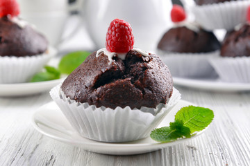 Delicious chocolate cupcake with raspberry on table close up