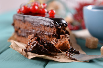 Tasty chocolate cake with berries and cup of tea on table close up