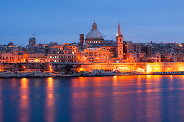 Fototapeta na wymiar Valletta seafront skyline view as seen from Sliema, Malta. Illuminated historical buildings after sunset.