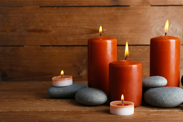 Obraz na płótnie Canvas Beautiful spa stones with candles on wooden background