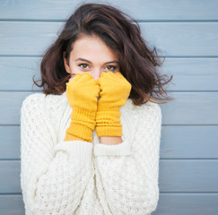 Beautiful natural young smiling brunette woman wearing knitted sweater and gloves. Fall and winter...