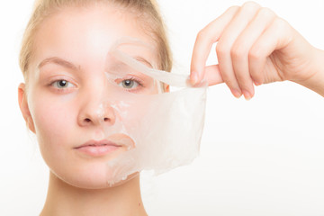 girl removing facial peel off mask