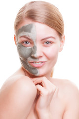 Skin care. Woman applying clay mask on face. Spa.