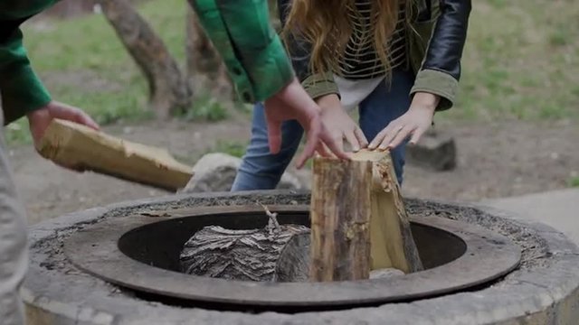 Medium panning shot of couple building campfire / American Fork Canyon, Utah, United States