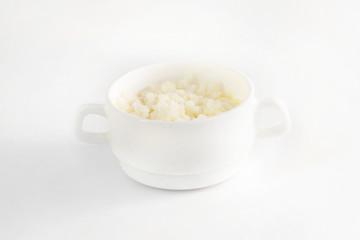 Bowl of fresh tasty rice porridge with piece of butter isolated