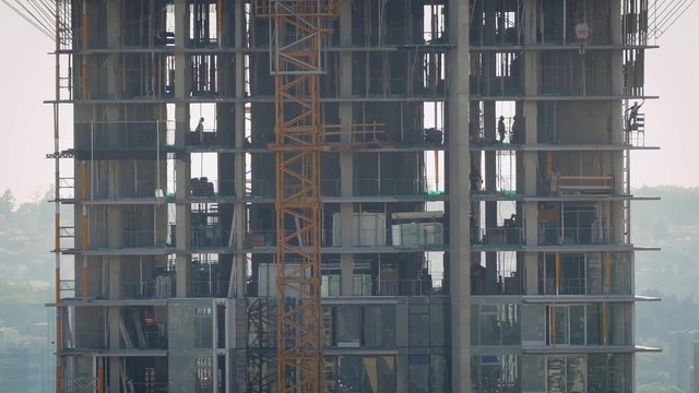 Workers Busy On Levels Of Building Under Construction