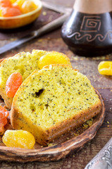 cake with kumquats and poppy seed on wooden background