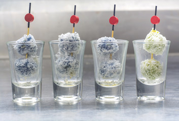 Co--Center filled steam rice ball with coconut fuzz, traditional Thai snack skewer in glassware